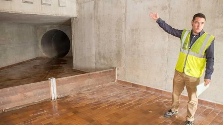 El técnico de Aguas de Alicante Luis Cutillas muestra la tubería por la que entra el agua que se acumula en el parque La Marjal.