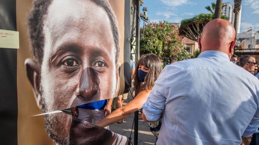 Luz Sosa, autora de las fotografías de ‘Las Raíces’, ayuda a reparar una de las imágenes dañadas, junto al alcalde, Marco González (PSOE). | | E.D.