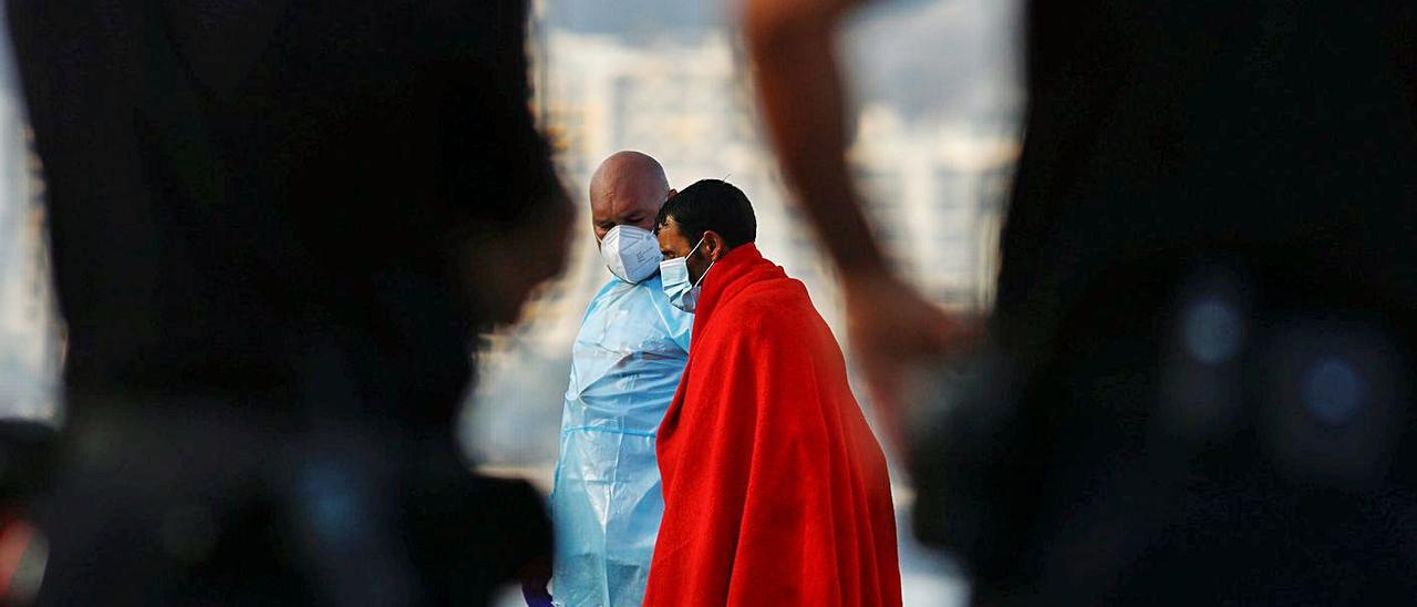 Un inmigrante desembarca en el puerto de Arguineguín, en Gran Canaria, tras su rescate. | | BORJA SUÁREZ/ REUTERS