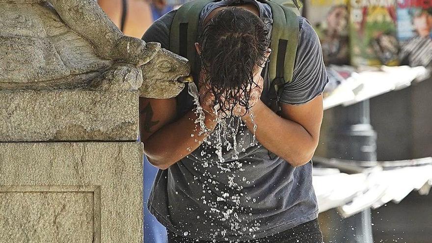 Un noi es refresca en una font al Barri Vell de Girona, ahir