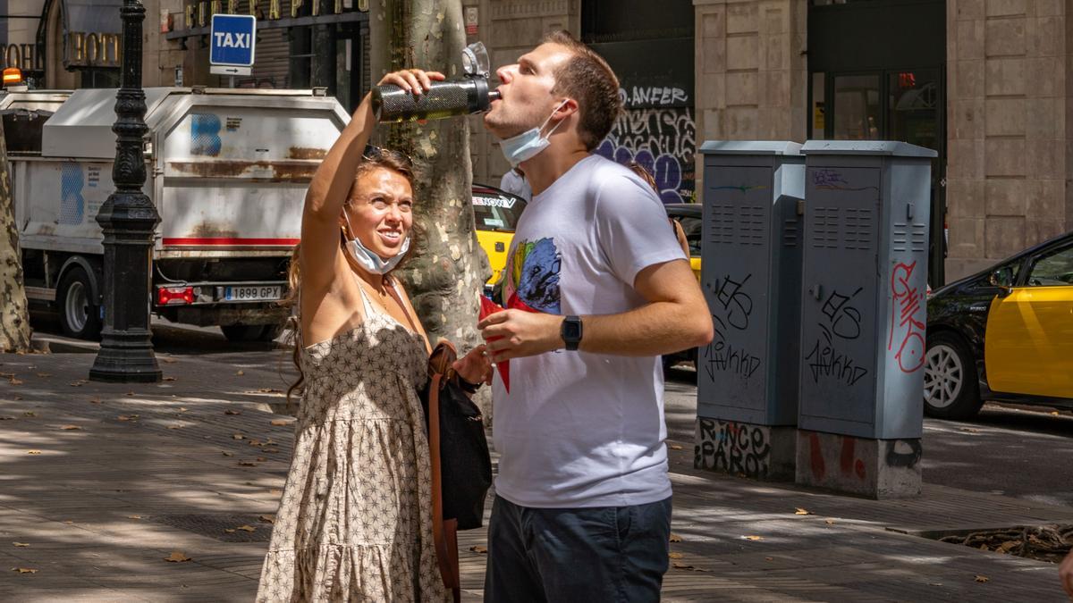 Ola de calor en Barcelona. En la foto: turistas tomando agua