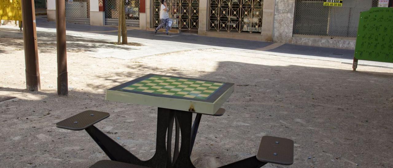 La mesa pintada con un tablero de ajedrez permanece intacta en el parque infantil. | PERALES IBORRA