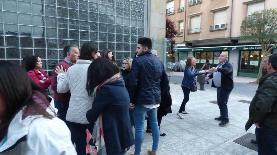 A la derecha, José García, que apoya a Seoane, se enfrenta con afiliados del PP afines a la dirección, ayer, frente a la Casa de Cultura de Lugones. A la izquierda, otros afiliados discuten con el tesorero.