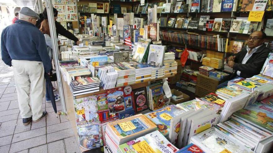 Varios clientes hojean los libros de Marcos Cachuán, a la izquierda.