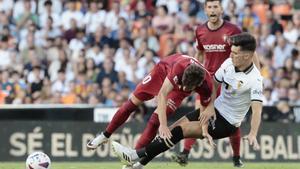 El centrocampista de Osasuna Aimar Oroz (i) disputa una posesión ante Pepelu, centrocampista del Valencia durante el partido correspondiente a la Jornada 3 de LaLiga que enfrentó a Valencia y Osasuna este domingo en Mestalla. EFE/ Ana Escobar
