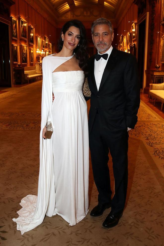 Amal Clooney, con un vestido blanco, y George Clooney, de esmoquin