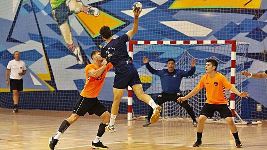 Dos jugadores del Torrelavega, de naranja, intentan frenar el avance de un jugador del Rutas del Vino.