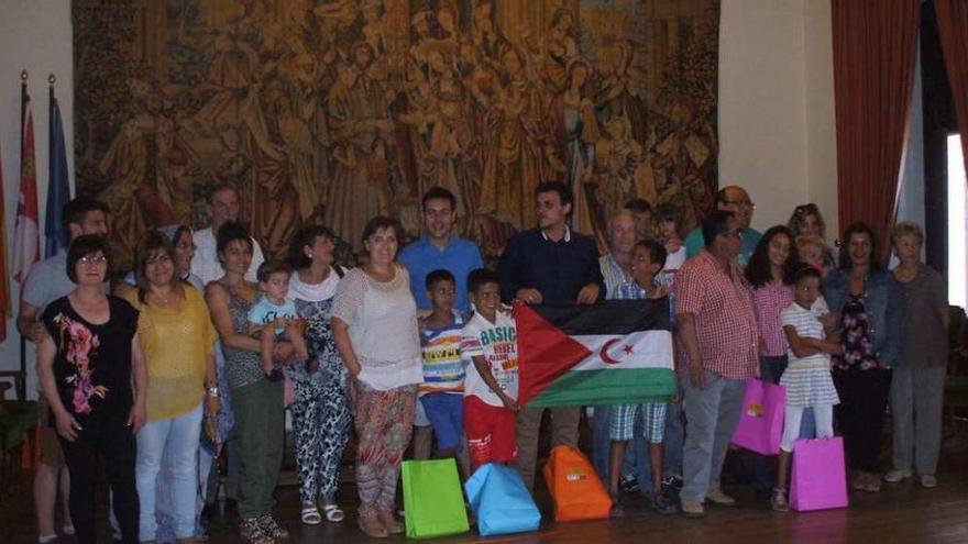 Los niños, sus familias de acogida y autoridades locales posan en una foto de familia. Foto