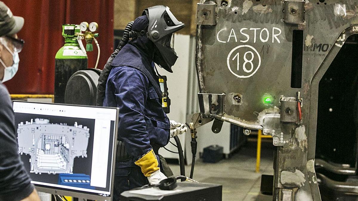 Operarios de Santa Bárbara, en el taller, durante el montaje de un blindado. | Irma Collín