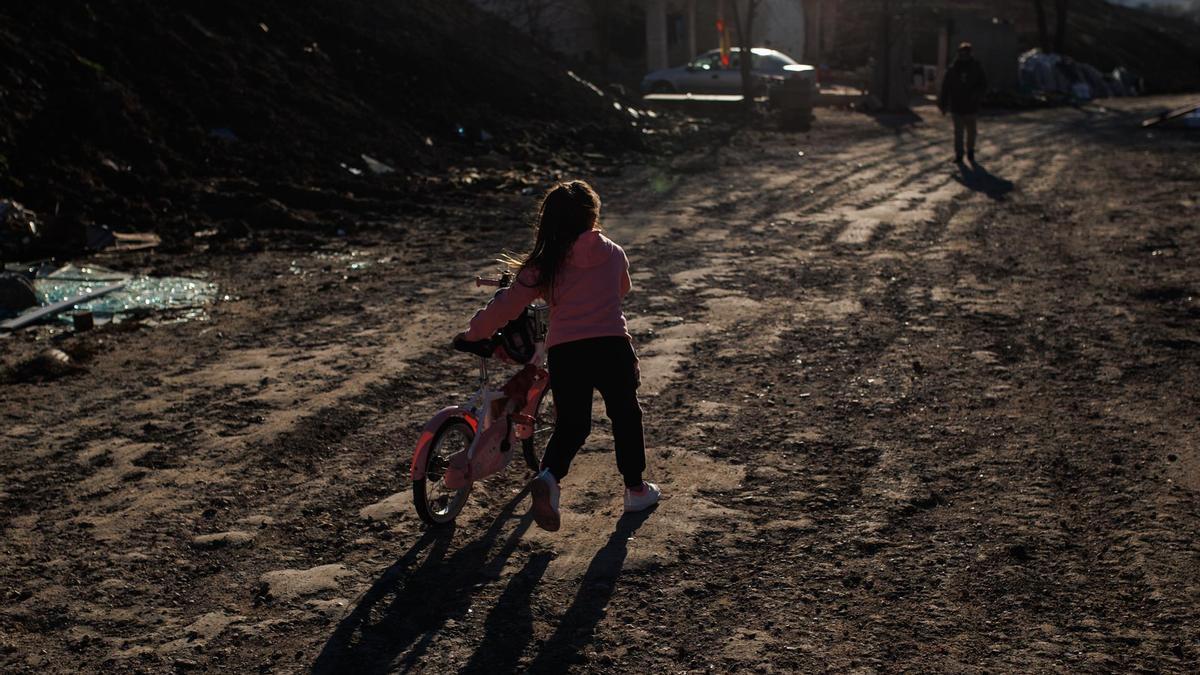 Una niña con una bicicleta en el sector VI de la Cañada Real.