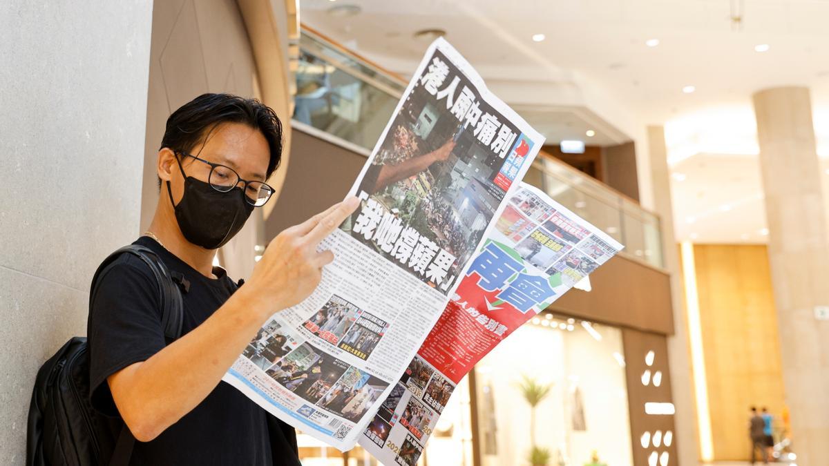 An Apple Daily supporter reads the final edition of the newspaper at a shopping mall in Hong Kong