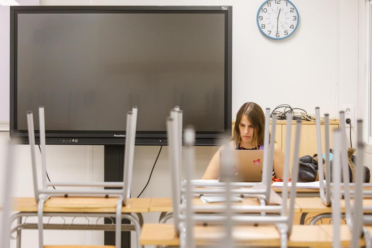 Una profesora de secundaria prepara el curso en un aula todavía vacía.