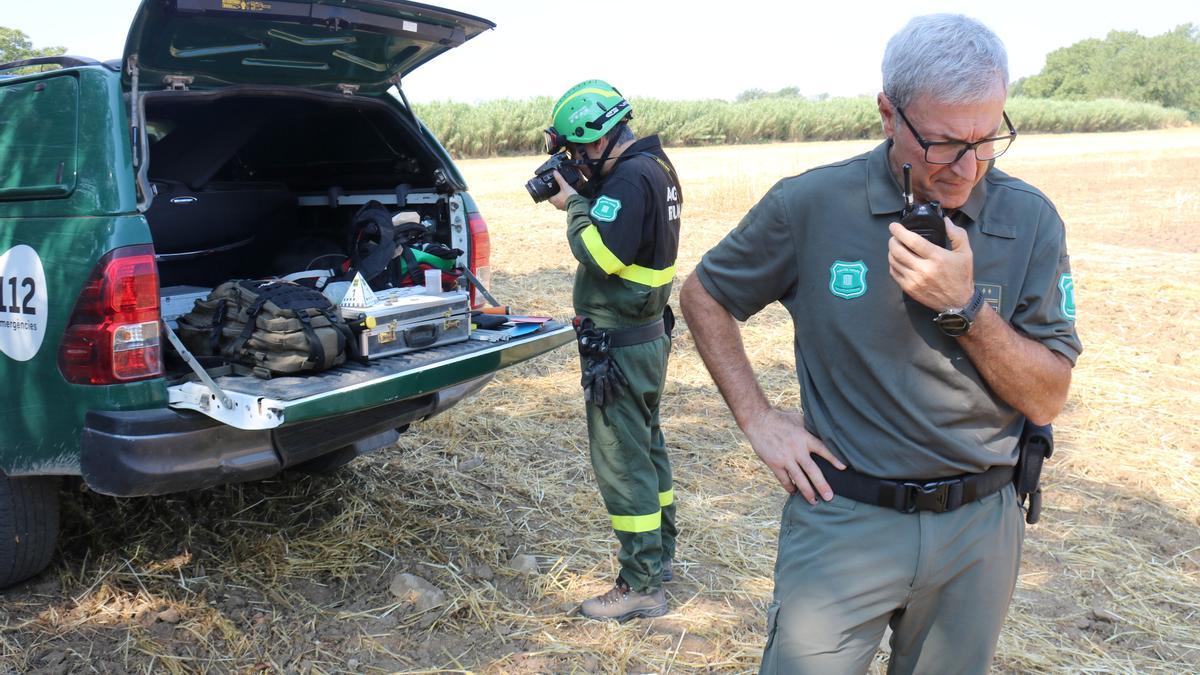 Dos membres del cos d&#039;Agents Rurals treballant a la zona on es va originar un incendi en un camp a Sant Agnès de Malanyanes