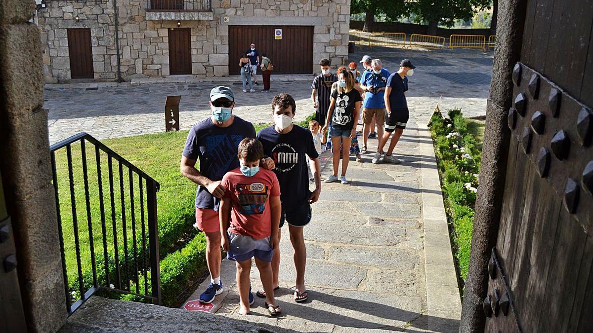 Turistas con mascarilla hacen cola para entrar en el castillo de Puebla de Sanabria. | A. Saavedra