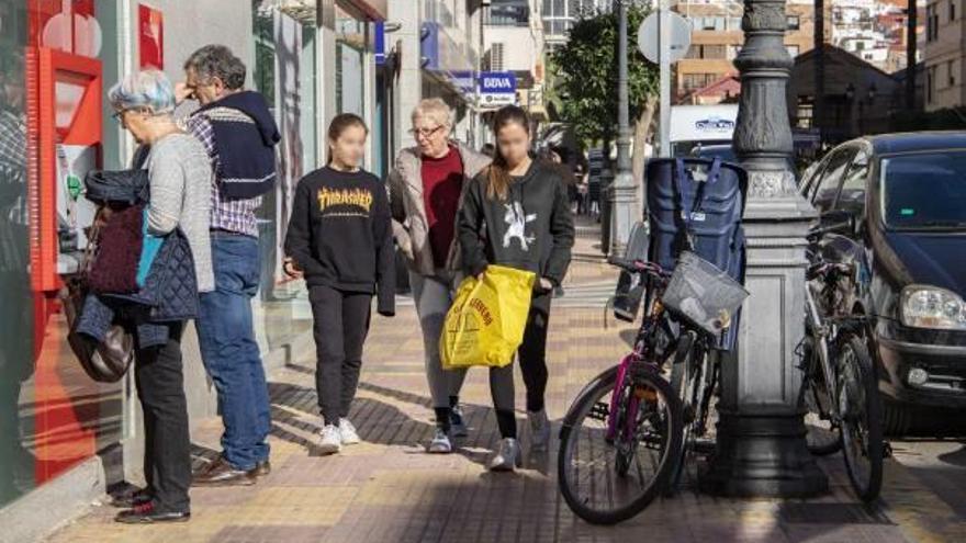 Varios vecinos se desplazan andando por una calle con presencia de bicicletas.