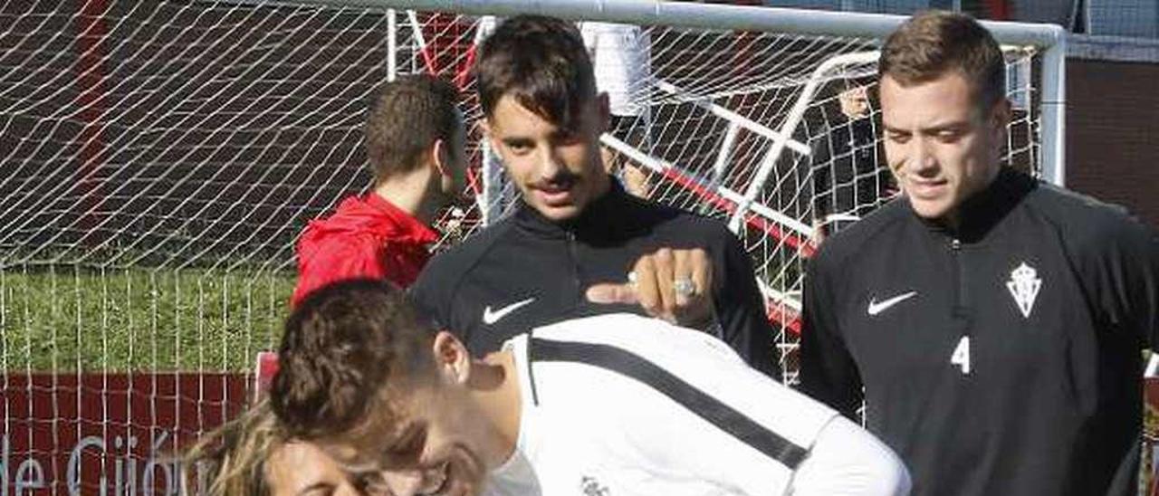 Lucas Ojanguren recibe de Nacho Méndez una camiseta firmada por todo el equipo antes de fotografiarse con la plantilla en el campo 2 de Mareo.