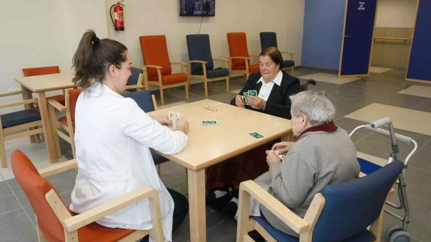 Una gerocultora juega a las cartas con dos usuarias de la residencia de Montamarta.