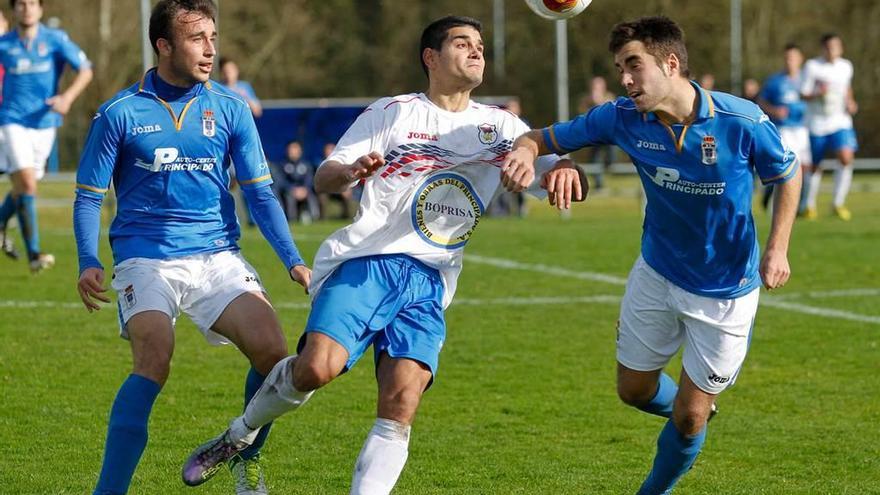 Chus controla el balón ante Adrián Llano y Diegui en el Oviedo B - Langreo de la 2013-14.