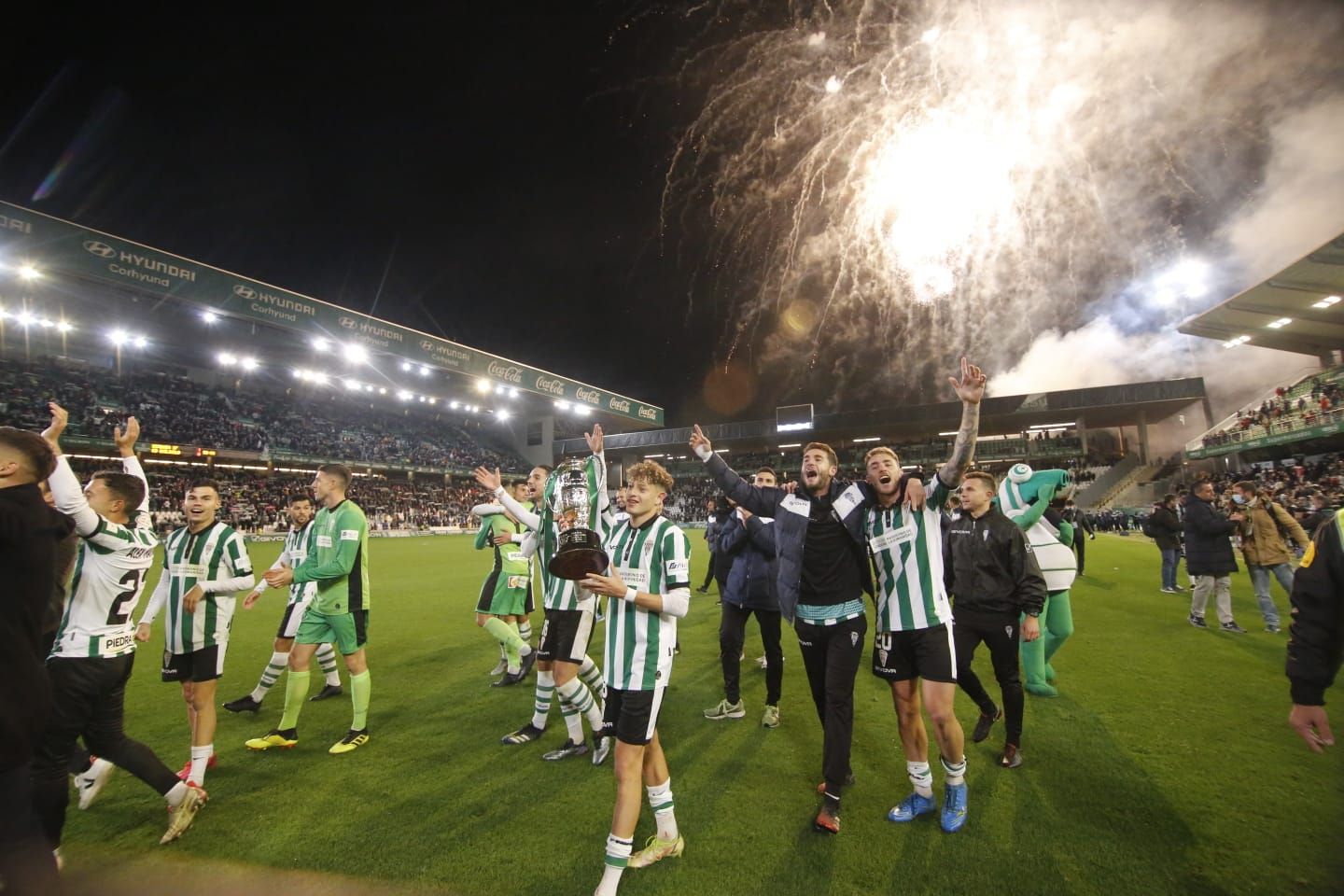 Los jugadores cordobesistas dan la vuelta de honor con los fuegos artificiales de fondo.