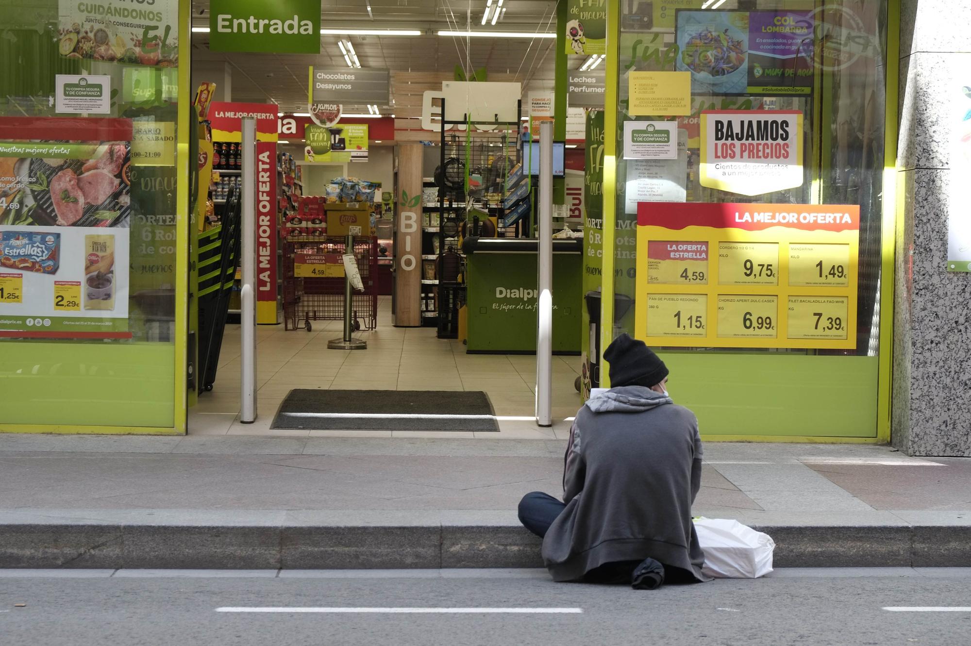 Una persona sin hogar mendiga a las puertas de un supermercado del centro de Elche.  | MATÍAS SEGARRA