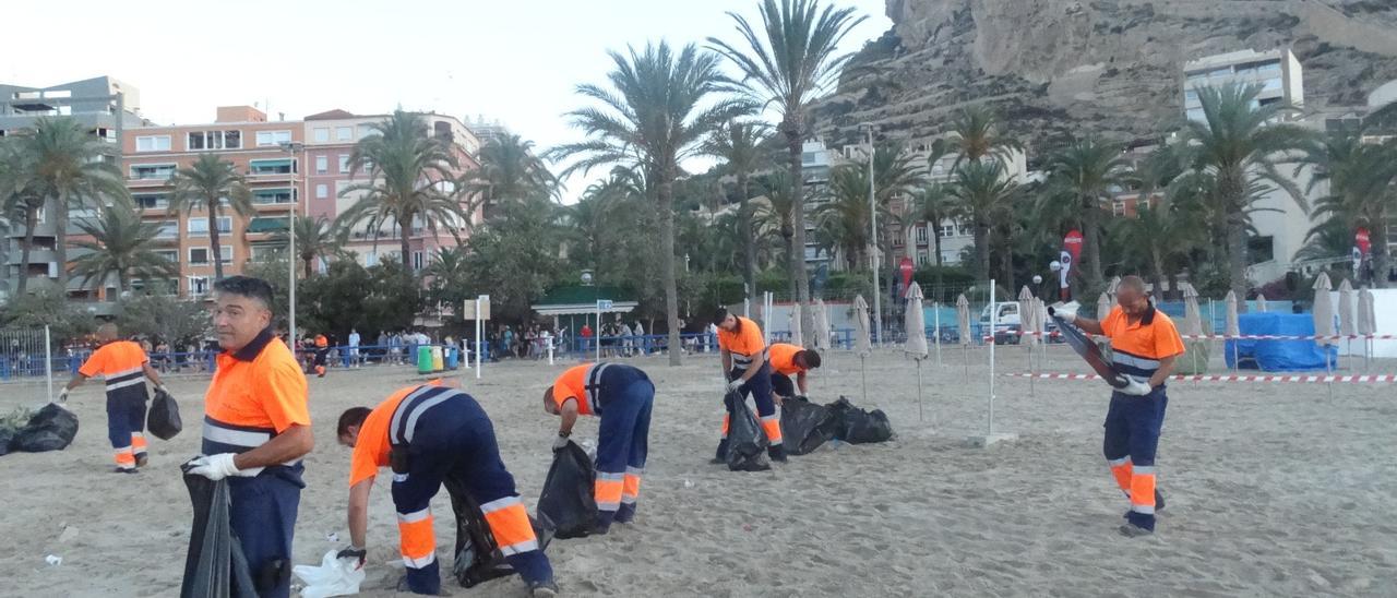 Limpieza por operarios de UTE Alicante de la playa del Postiguet estas Hogueras