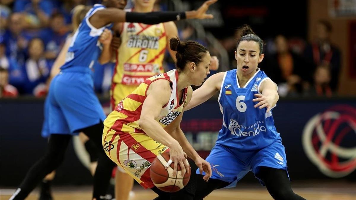 La jugadora del Uni, Nuria Martínez, conduce el balón presionada por Silvia Domínguez