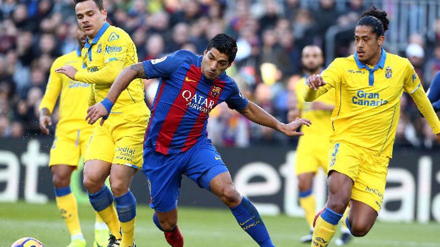 Luis Suárez trata de controlar el esférico, el pasado mes de enero, ante Roque Mesa -i- y Mauricio Lemos -derecha-, en el Camp Nou.