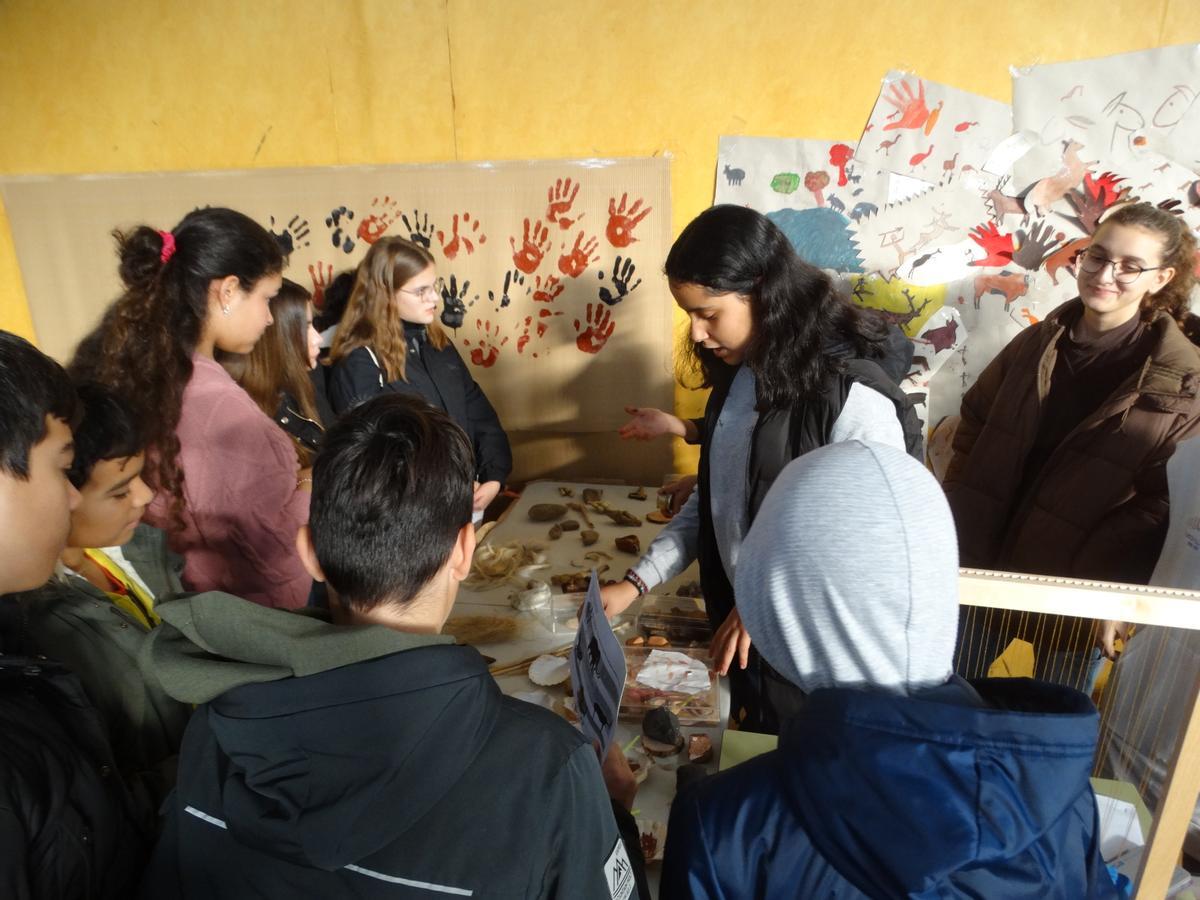 Explicación en el stand con distintas herramientas cotidianas de la Prehistoria.