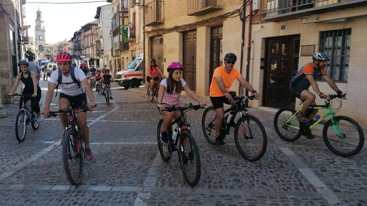Participantes en la marcha cicloturista circulan por la calle La Mayor y la plaza de la Colegiata. | M. J. C.