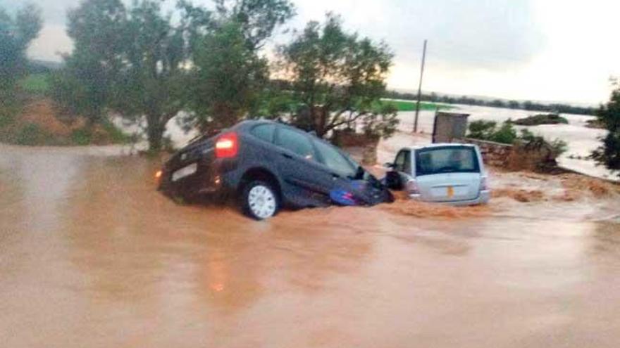 Dos de los coches que fueron arrastrados por la fuerza del agua ayer por la mañana cerca de Campos.