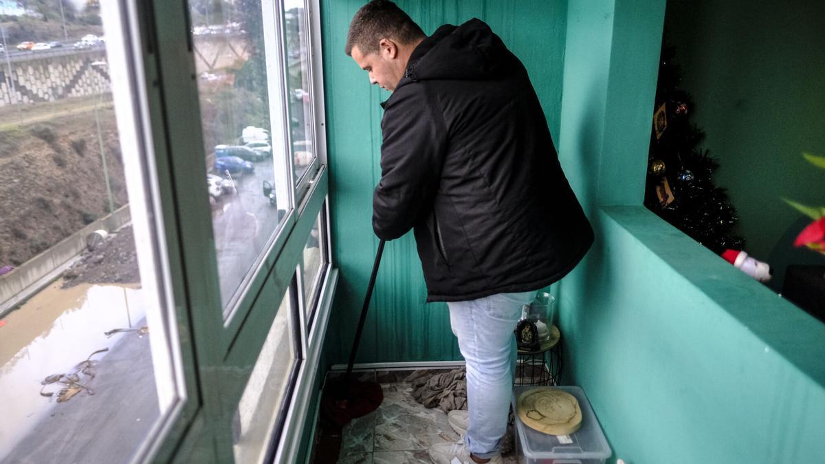 Darío Rodríguez escurre el agua que cae en su casa de La Paterna.