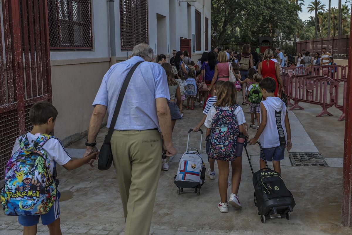 Familiares y niños en la entrada a un colegio de Elche