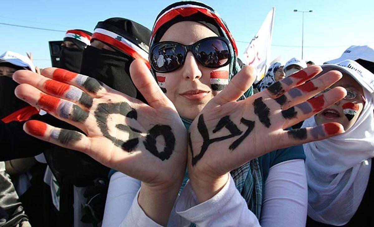 Una dona siriana, en una protesta a l’Ambaixada de Síria a Amman (Jordània), mostra les mans, en què es pot llegir en anglès i àrab la paraula ’Vés-te’n’, en referència al president sirià, Baixar al-Assad.