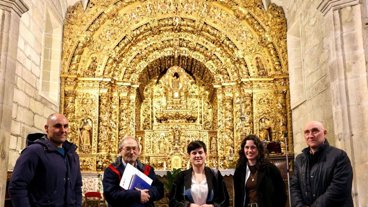 La alcaldesa de O Rosal, junto al párroco e investigadores, en el retablo de Santa Mariña.