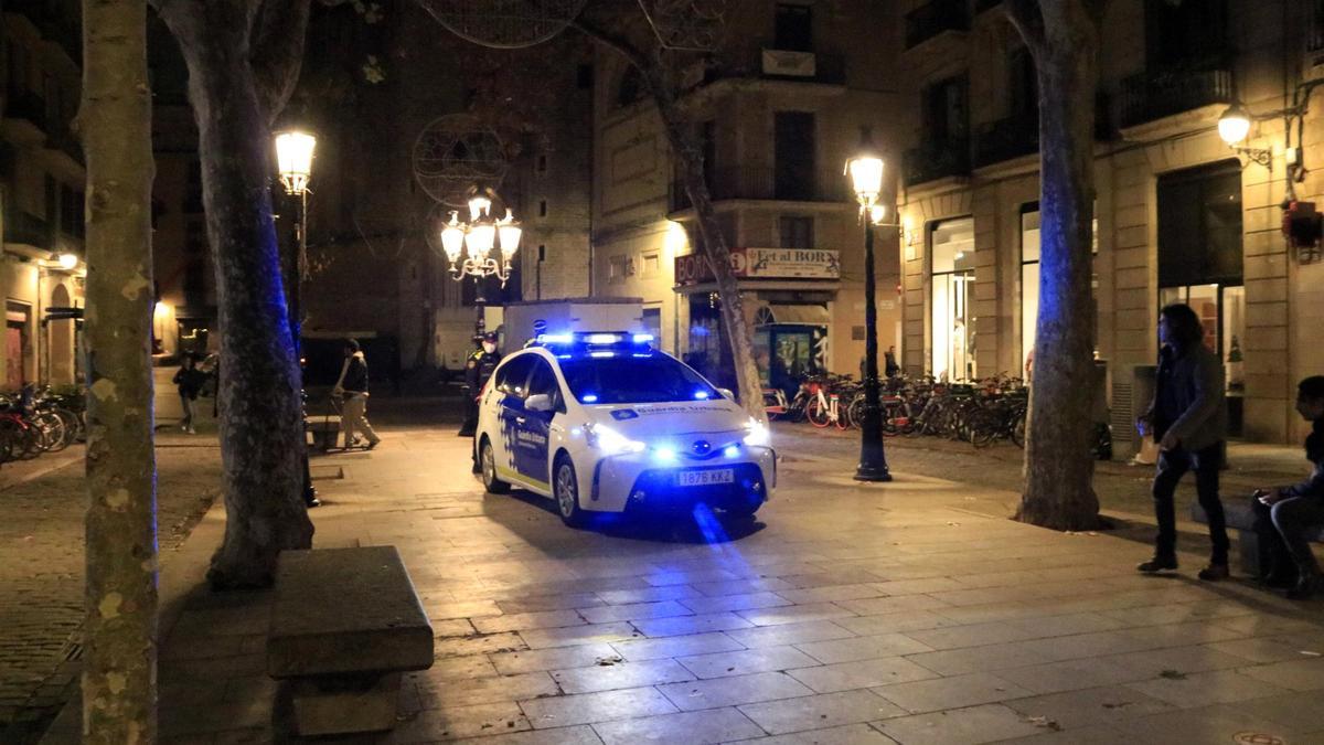 Un cotxe de la Guàrdia Urbana de Barcelona circula pel passeig del Born una mica abans de la una de la matinada per començar a informar del toc de queda decretat