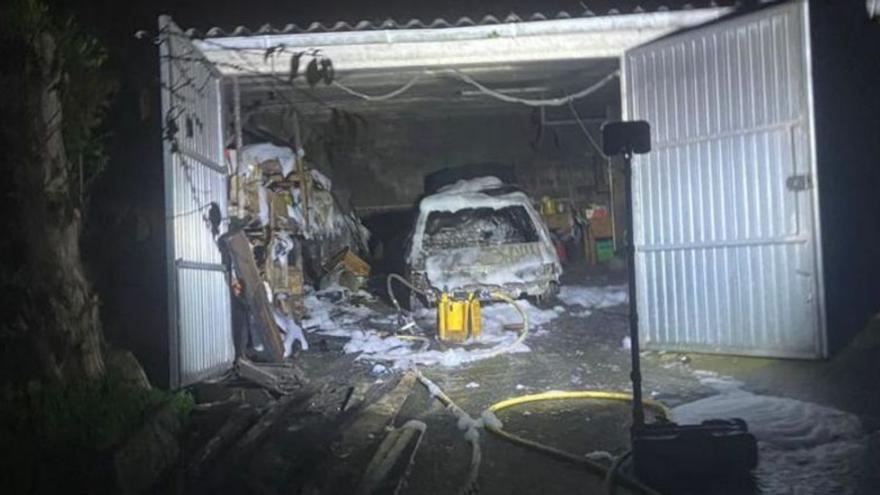 Un incendio calcina dos vehículos y material almacenado en un garaje