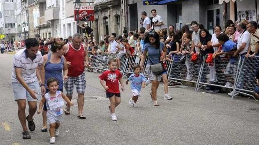 Niños, junto a sus padres, corriendo en una carrera popular. // N. Parga
