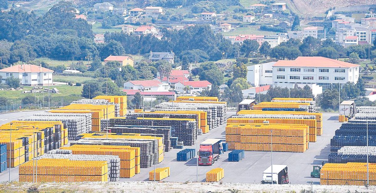 Miles de cajas y de barriles de Estrella Galicia, en una parcela anexa a la fábrica.