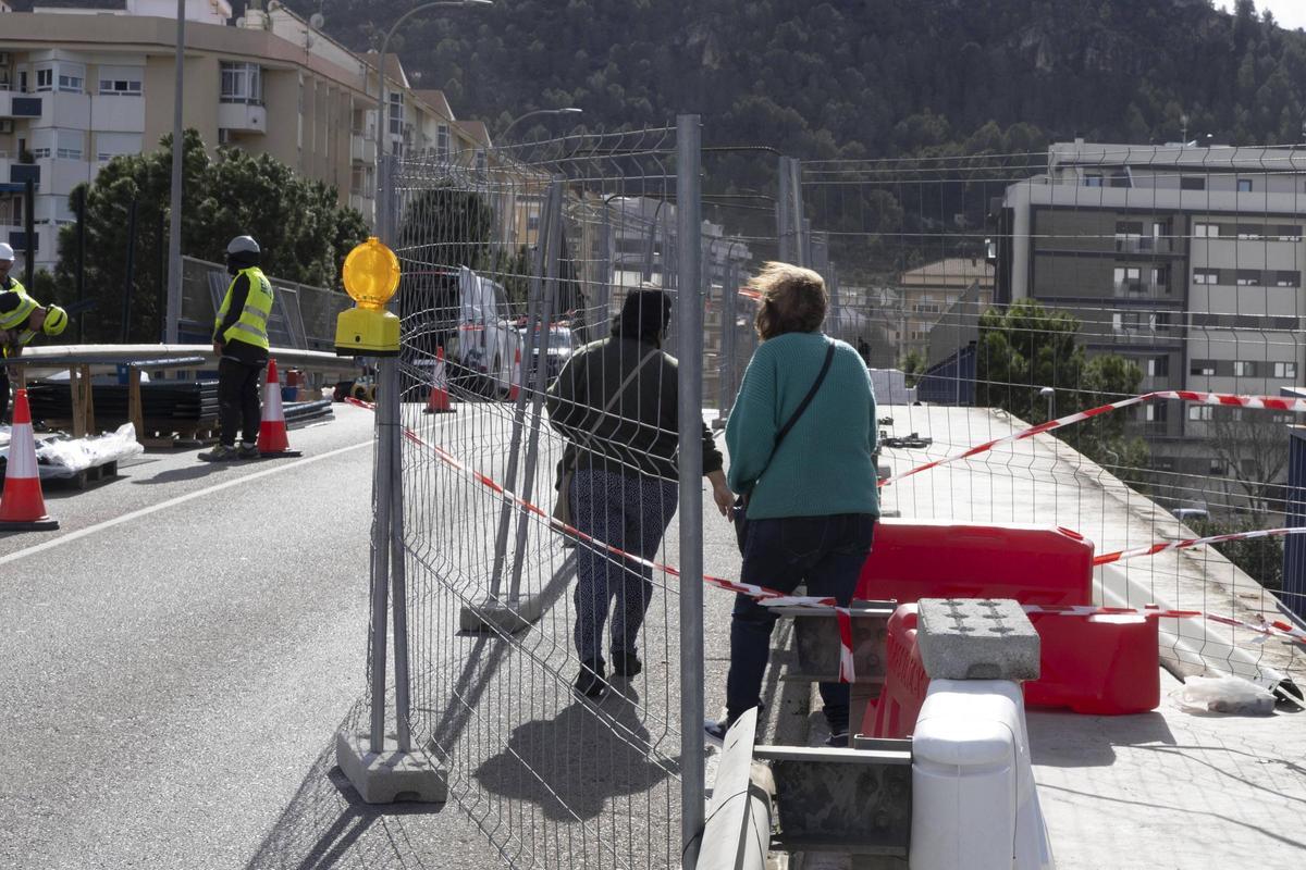 Dos mujeres cruzan por la zona acotada en el puente durante las obras.