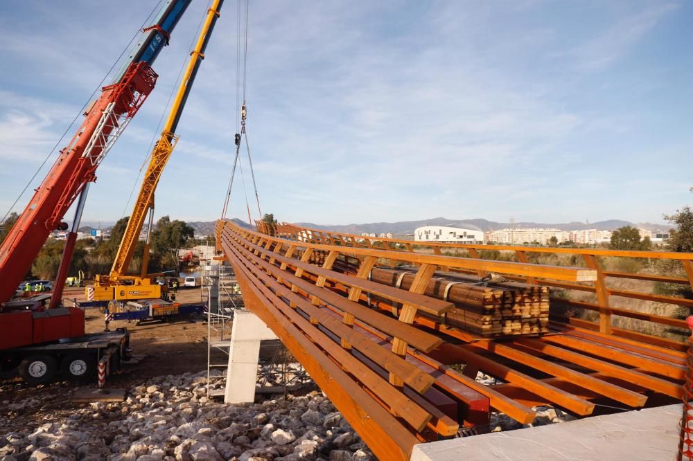 Comienzan a instalar la nueva pasarela de madera del Guadalhorce