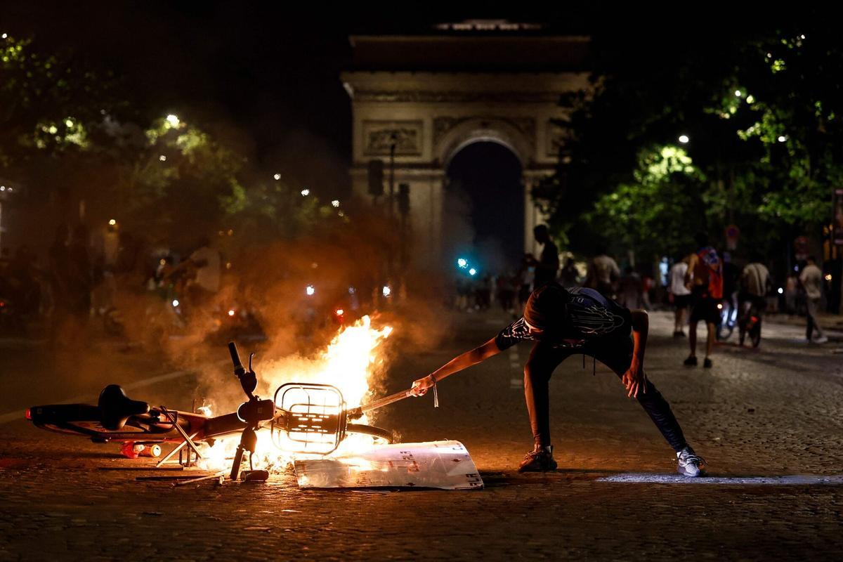 Una bicicleta ardiendo frente al Arco de Triunfo de París, en los disturbios durante las celebraciones por la victoria en la Champions del PSG.