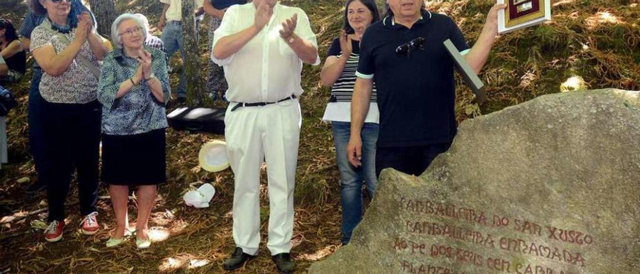 Xosé Lois González, O Carrabouxo, muestra la placa con la que fue obsequiado por los vecinos. // R. V.