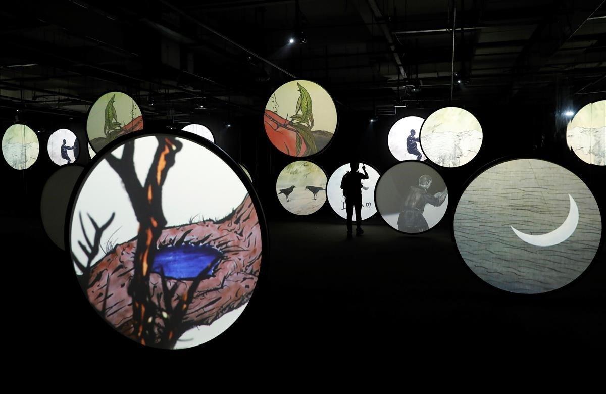 Un visitante observa la obra de arte digital Miles de Lunas, del artista chino Wu Junyong, mientras recorre la exposición artística Asia Digital en Pekín (China), este jueves. La muestra exhibe obras de una treintena de artistas de 12 países.