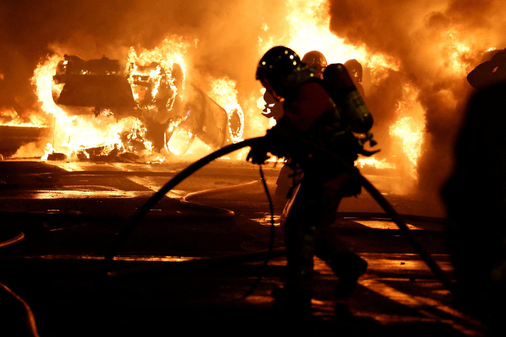 Un bombero extingue un vehículo incendiado durante las protestas en Francia por la muerte del joven Nahel.