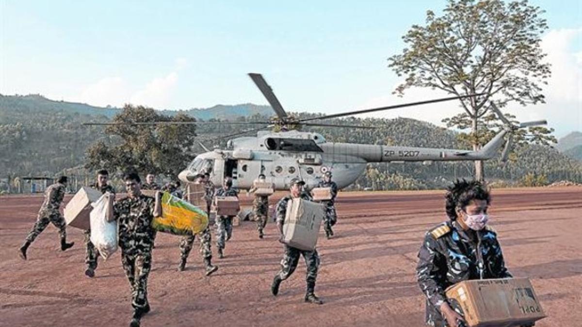 Personal nepalí carga con material de ayuda de un helicóptero de la India, ayer.