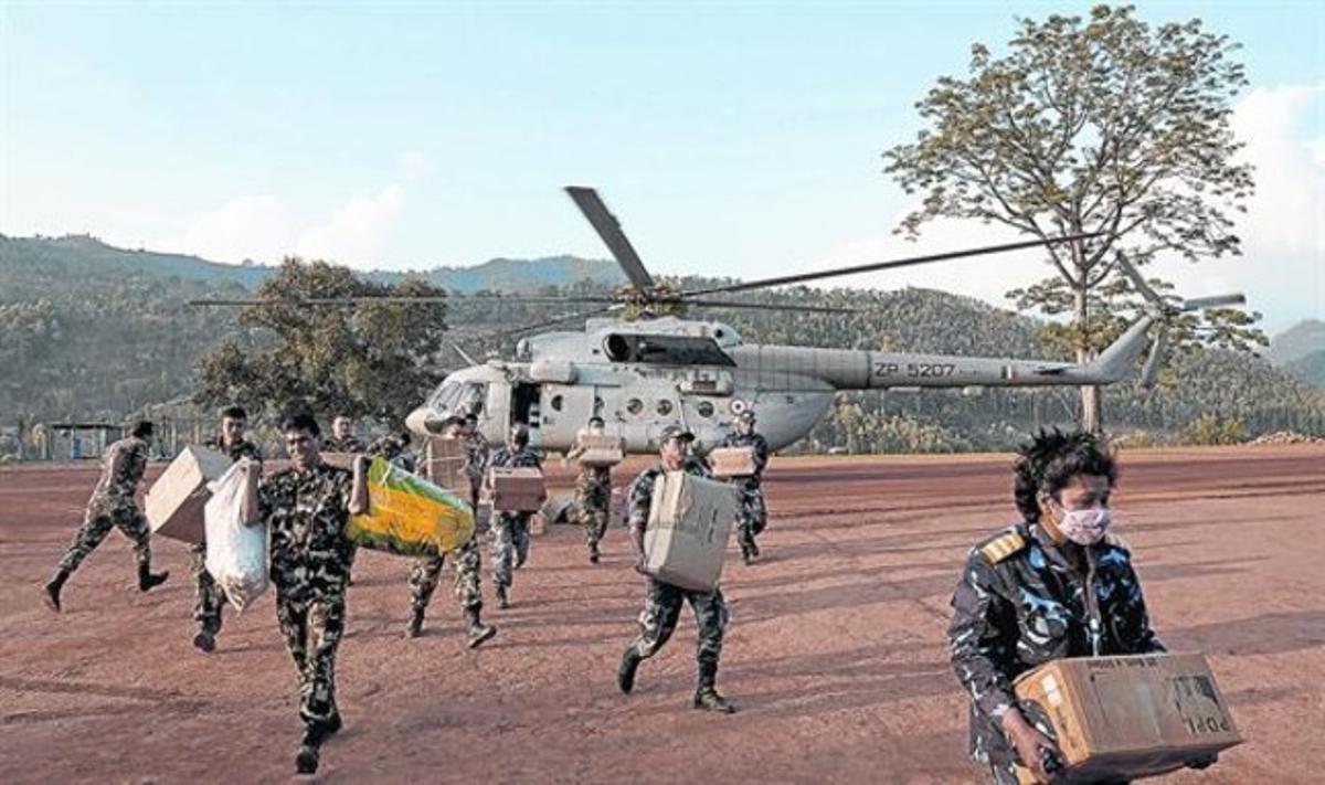 Personal nepalès descarrega material d’ajuda d’un helicòpter del’Índia, ahir.