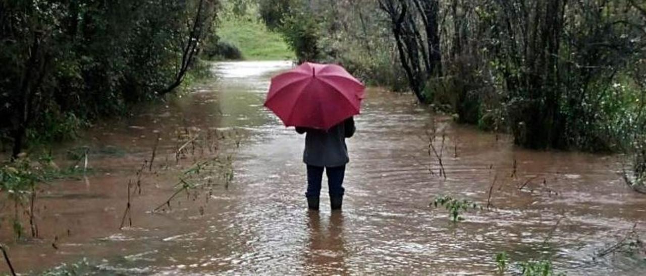 Un vecino, cruzando un camino anegado en la zona hace unos días.