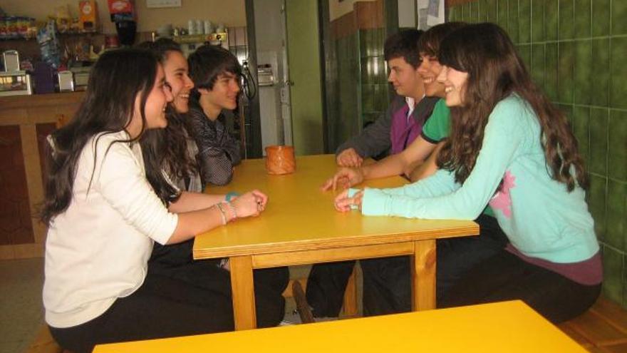 Varios alumnos sentados en dos de los nuevos bancos de la cafetería del Instituto de Salas.