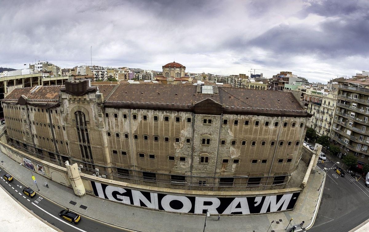 Artistas urbanos pintan los muros de la cárcel Modelo de Barcelona.