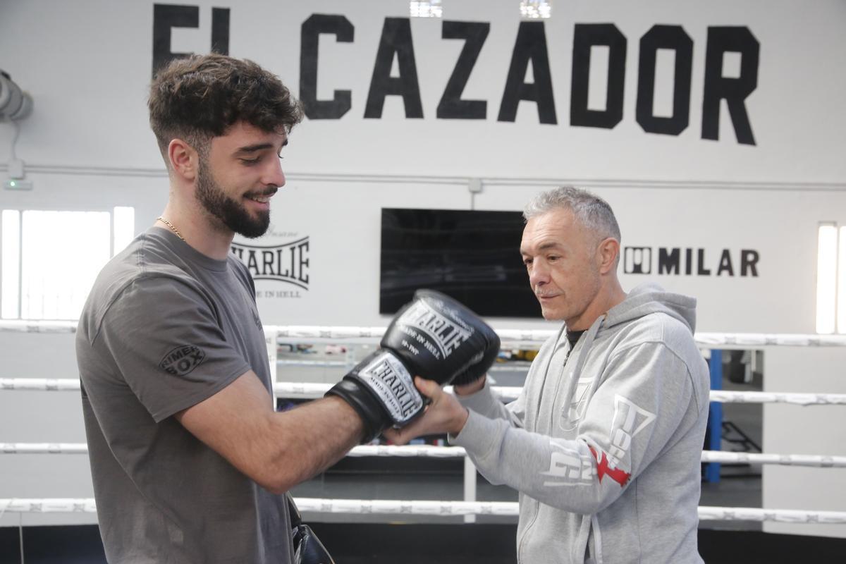 José Luis Navarro coloca los guantes a su hijo en el gimnasio de Chinales.